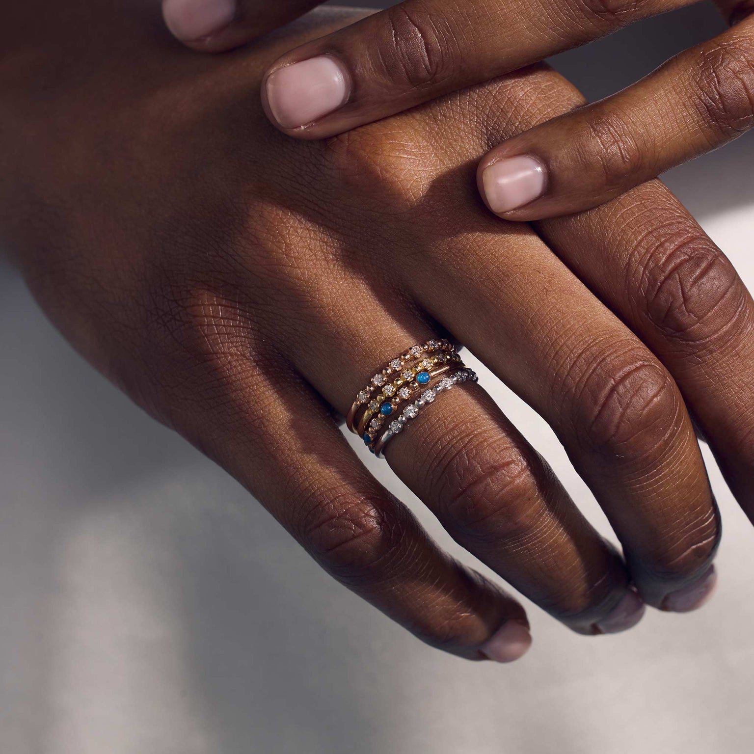 Photo des mains d’une femme portant différentes bagues Gigi Clozeau.