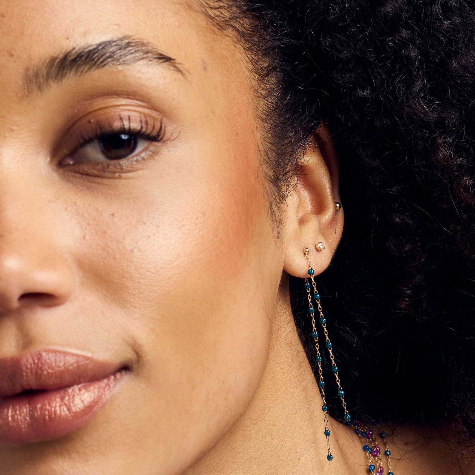 Moitié du visage d’une femme portant des boucles d’oreilles Gigi Clozeau.