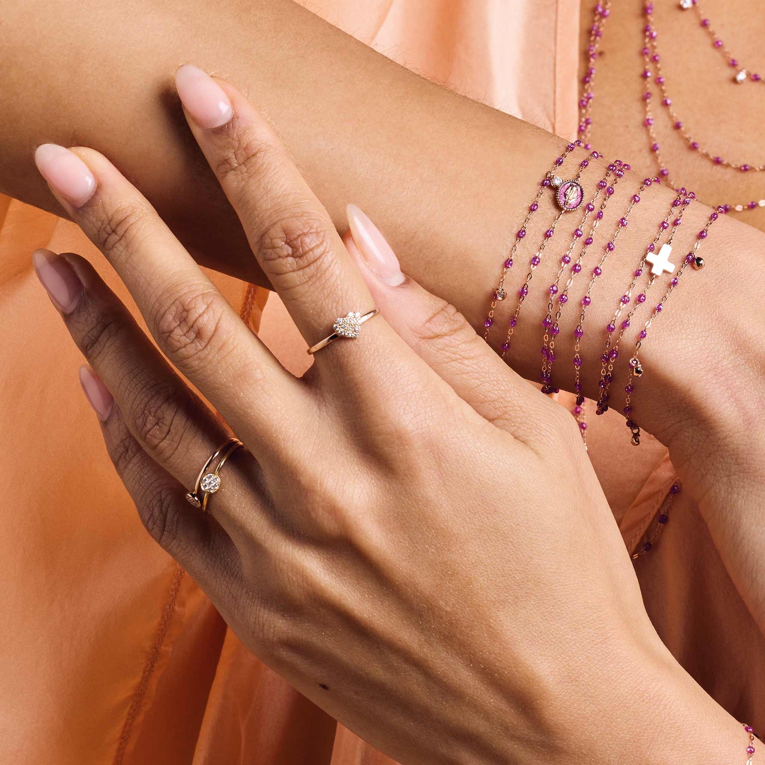 Photo du poignet et de la main d'une femme portant des bracelets et des bagues Gigi Clozeau de couleur galaxy.