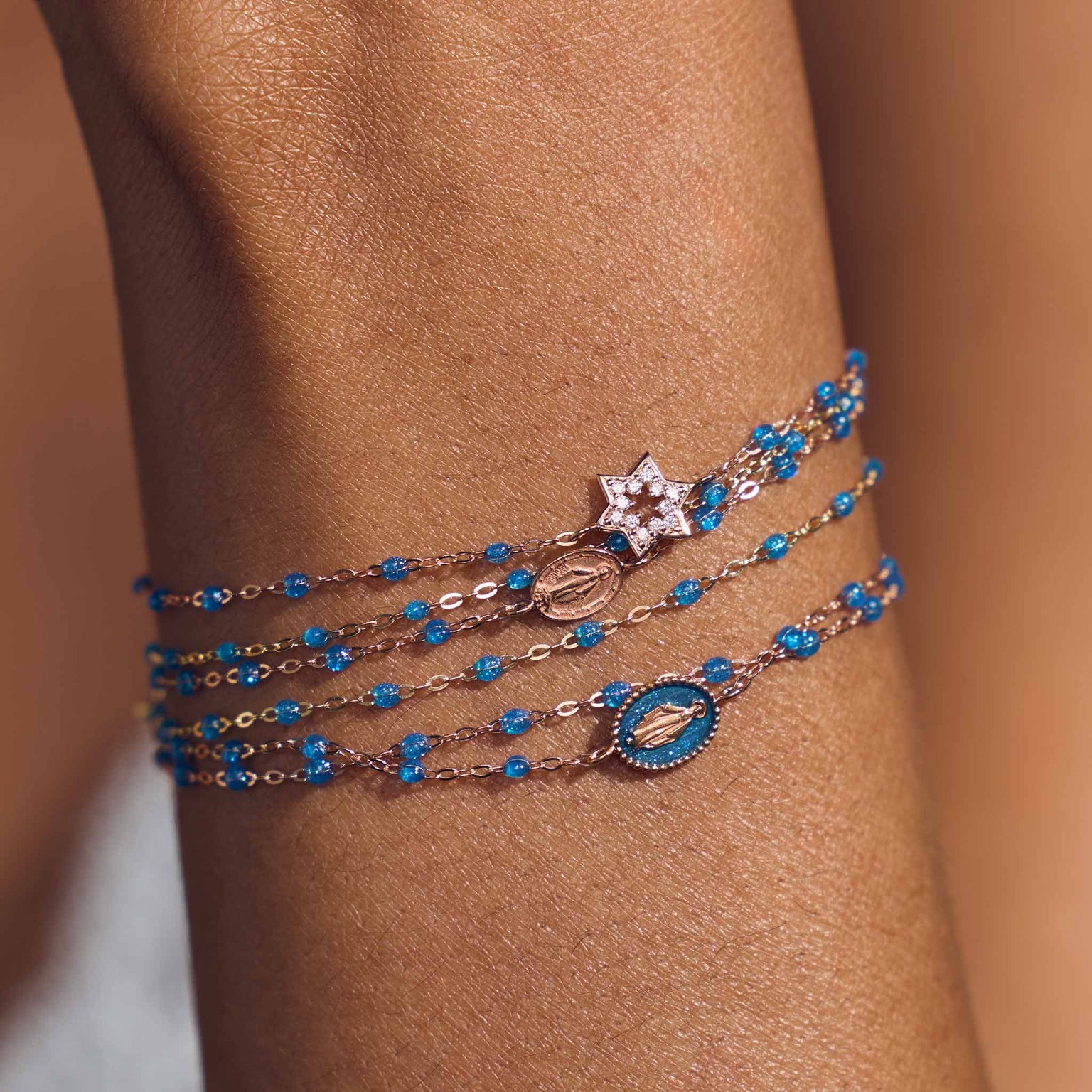 Photo du poignet d’une femme portant des bracelets Gigi Clozeau de la nouvelle couleur azur.
