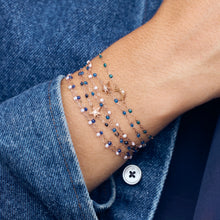 Photo du poignet d’une femme portant des bracelets Gigi Clozeau de couleur bleue.