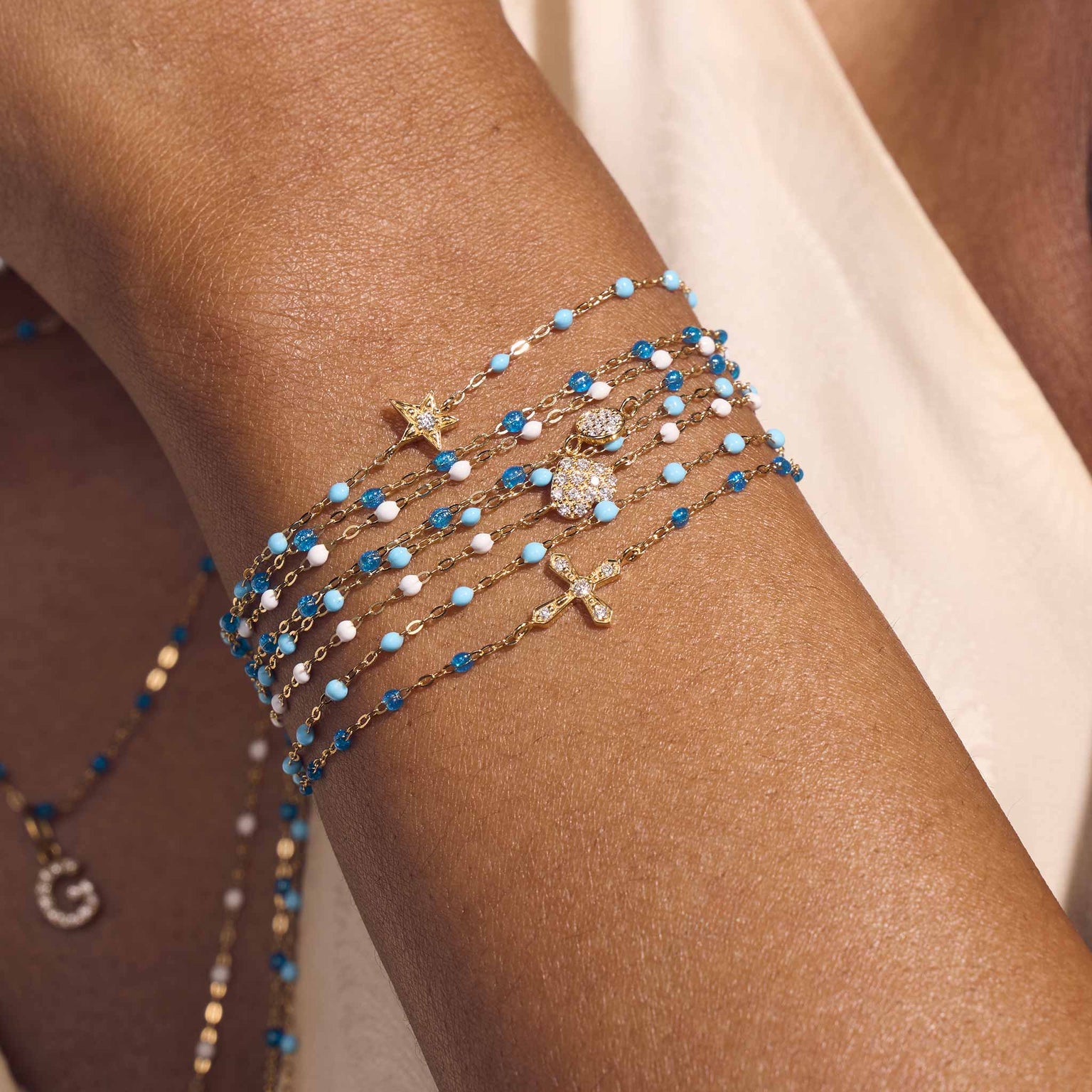 Photo du poignet d’une femme portant différents bracelets Gigi Clozeau.