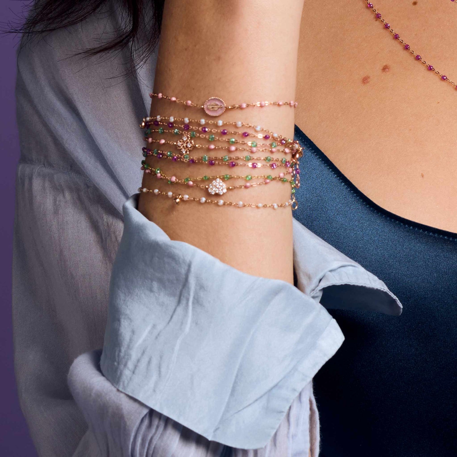 Photo du poignet d’une femme portant des bracelets Gigi Clozeau de différents modèles et couleurs.
