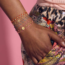 Photo du poignet d’une femme portant des bracelets colorés Gigi Clozeau.