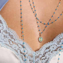 Photo du décolleté d’une femme portant deux colliers Gigi Clozeau de la nouvelle couleur azur.