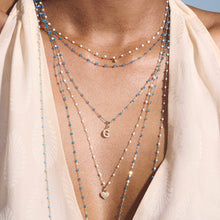 Photo du cou d’une femme portant différents colliers Gigi Clozeau.