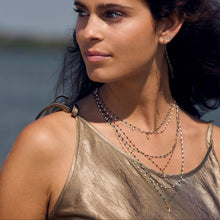 Photo d’une femme portant plusieurs colliers de différentes couleurs et modèles de Gigi Clozeau.